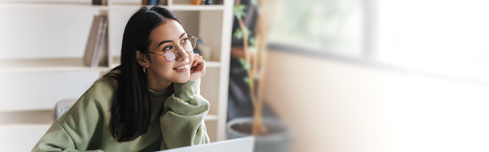 Junge Frau stützt ihr Kinn auf die Hand und lauscht interessant den Antworten auf die Coaching-FAQs. 