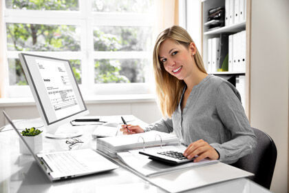 eine Frau sitzt an einem Schreibtisch mit einem Laptop