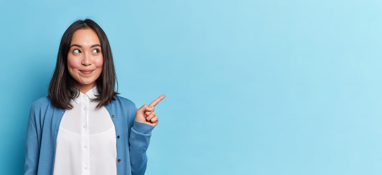 junge Frau lächelt und zeigt mit dem Finger nach links