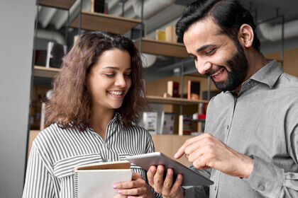 ein Mann und eine Frau schauen auf eine Tablette