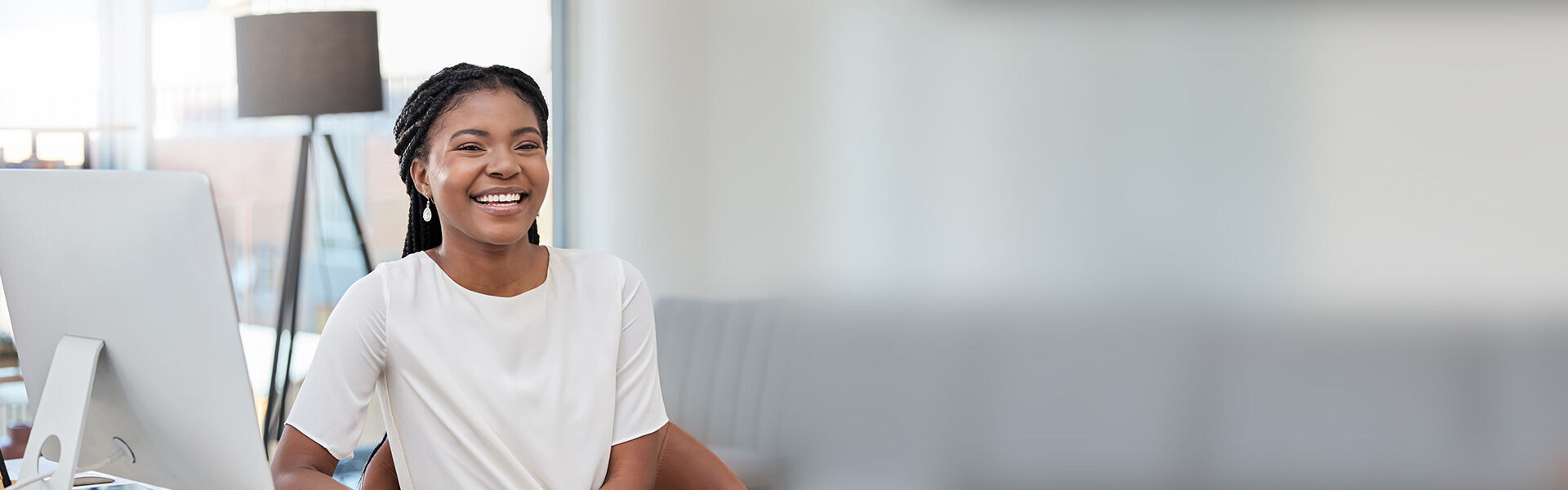 eine Frau, die mit einem Computer an ihrem Schreibtisch sitzt