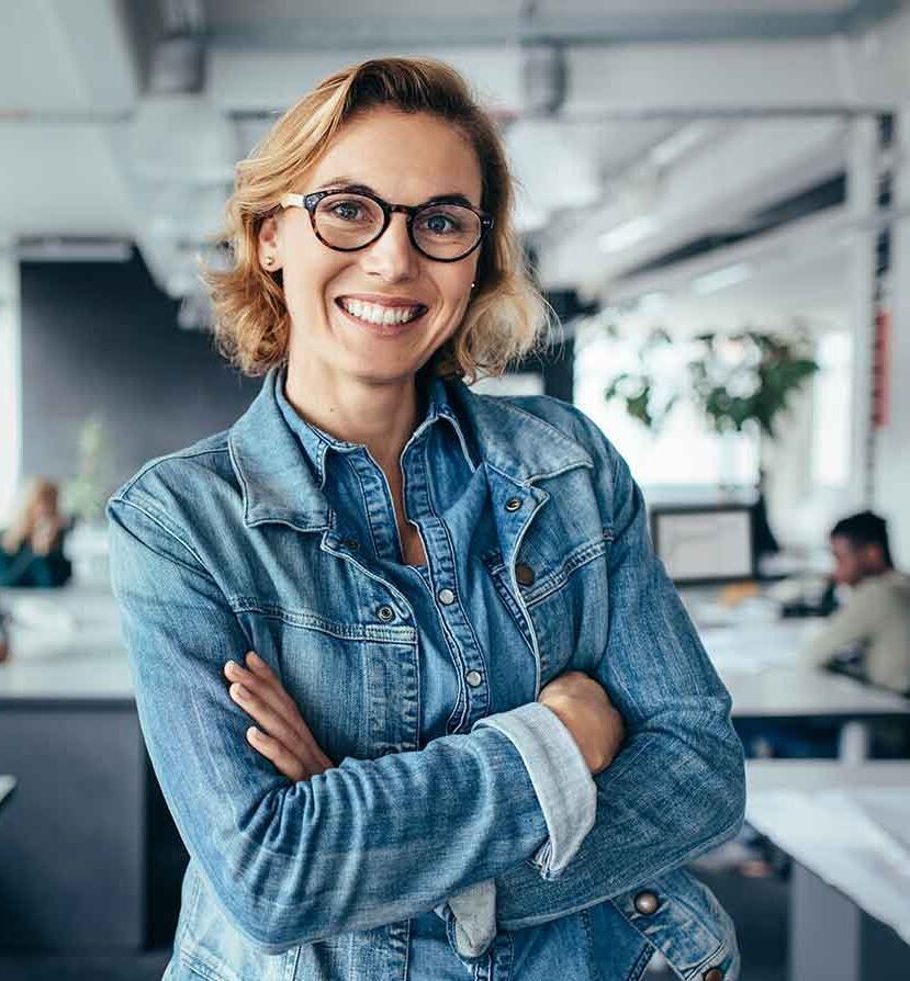 eine Frau in einem Büro mit gekreuzten Armen