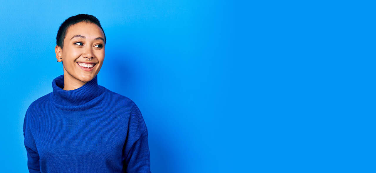 eine Frau in einem blauen Pullover und schwarzer Hose