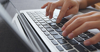 eine Person, die auf einem Laptop Computer tippt