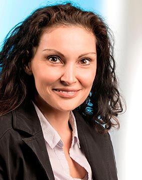 eine Frau in einer schwarzen Jacke und schwarzen lockigen Haaren